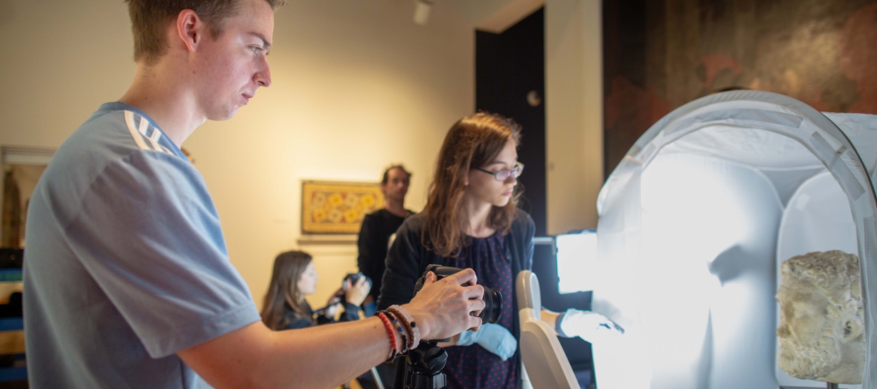 student using a digital camera in an art gallery for 3D documentation
