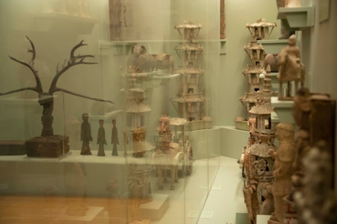 image of ceramics from china in a glass case. Som wood sculptures as well