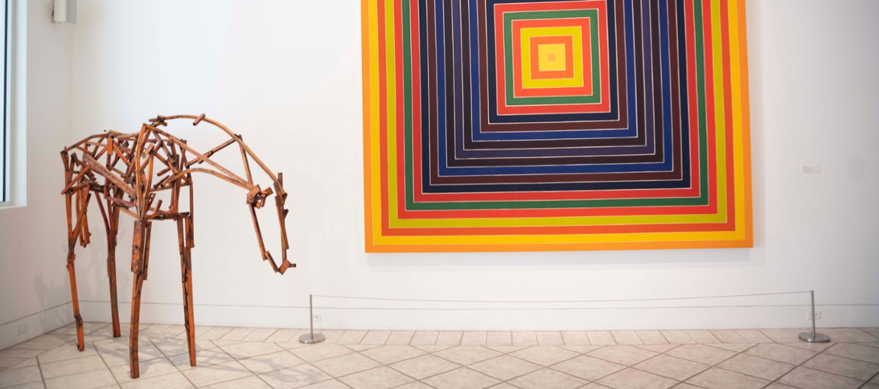 image of a metal sculpture of a horse and a geometric abstract painting in orange, red, blue and violet