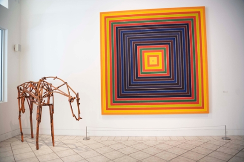 image of a metal sculpture of a horse and a geometric abstract painting in orange, red, blue and violet