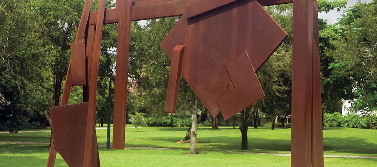 image of a contemporary abstract outdoor sculpture made of metal that is in sqaures and other geometric shapes. Metal is rust colored