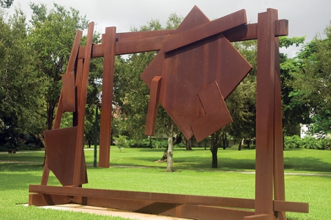 image of a contemporary abstract outdoor sculpture made of metal that is in sqaures and other geometric shapes. Metal is rust colored