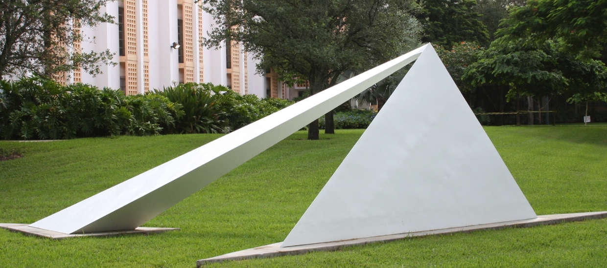image of a contemporary abstract outdoor sculpture made of metal that is in pyramidal and other geometric shapes. Metal is white colored