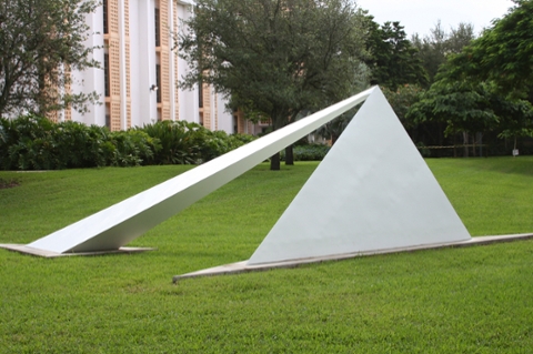 image of a contemporary abstract outdoor sculpture made of metal that is in pyramidal and other geometric shapes. Metal is white colored