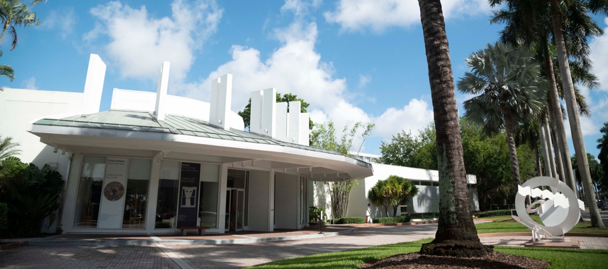 image depicting the fron exterior of the Lowe with abstract sculpture and palm trees in the foreground