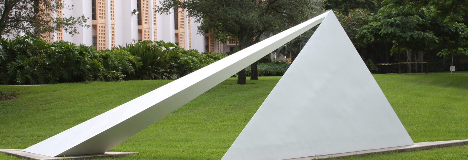 outdoor metal sculpture painted white consiting of triangular shapes leaning against one another