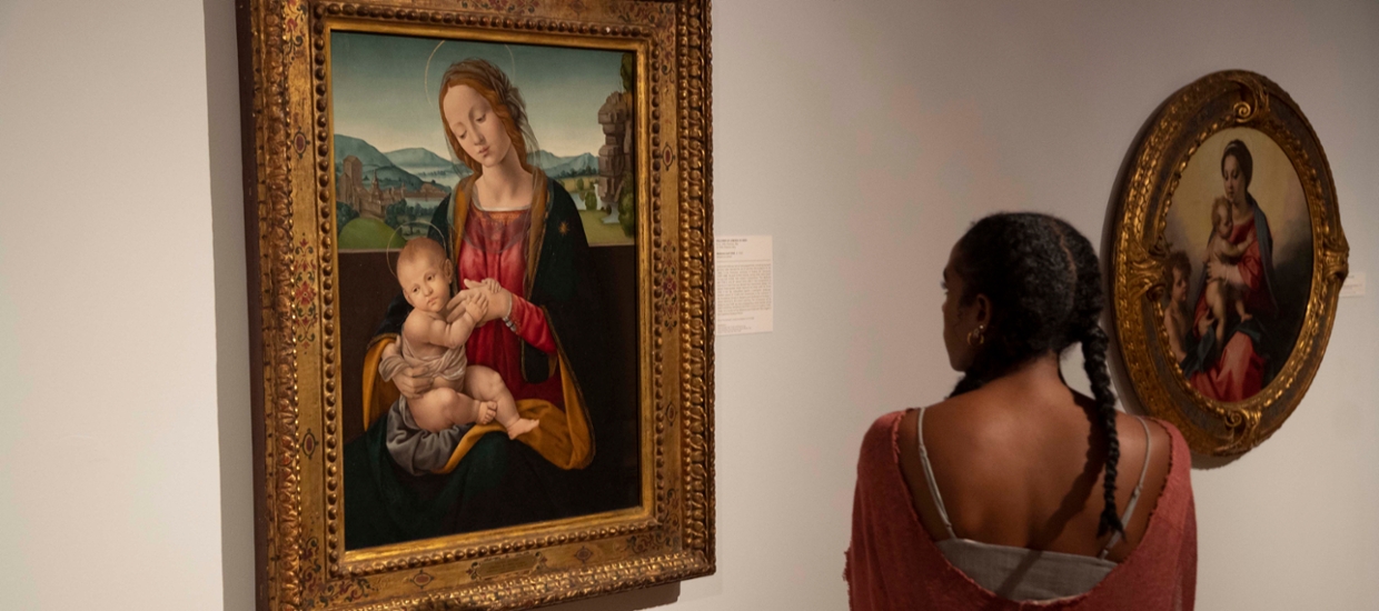 image of a woman looking at a classical style painting of Madonna and child