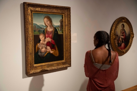 image of a woman looking at a classical style painting of Madonna and child