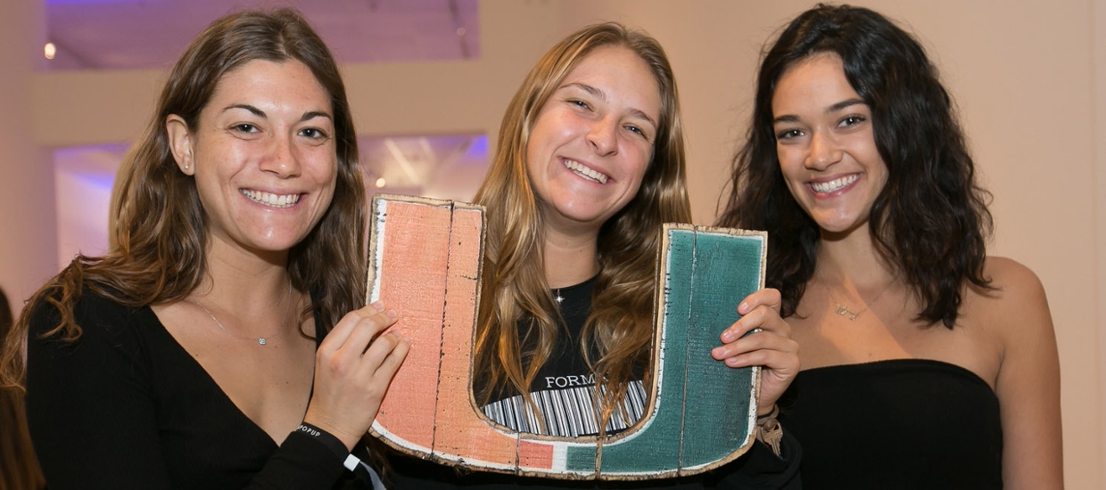 university students  holding up the U logo for the university of miami