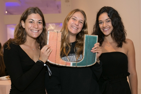 university students  holding up the U logo for the university of miami