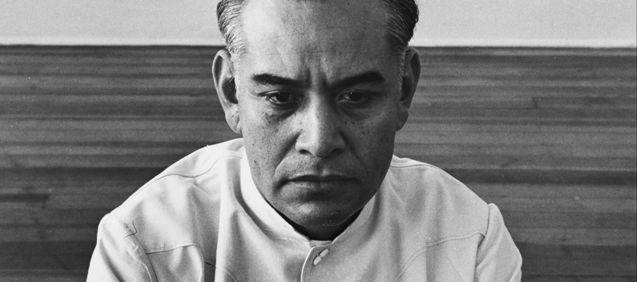 black and white photograph of a white man, close up of his face in a bare room