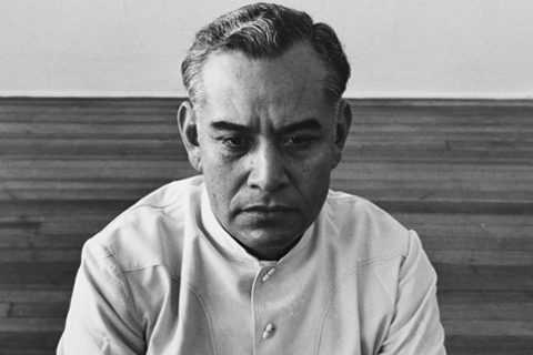 black and white photograph of a white man, close up of his face in a bare room