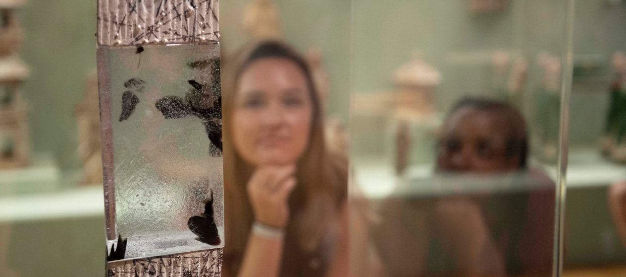 two young woman looking at a glass sculpture