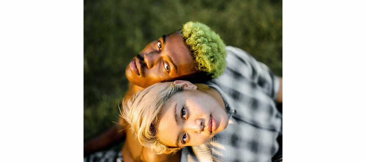 color photograph of a white woman and black man shot from above their heads. Each figure is looking up at the camera.