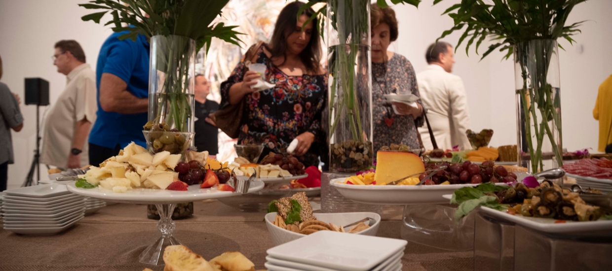 plates of food on a table with glass vases carrying flowers for a reception 