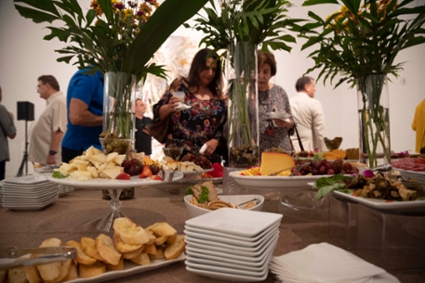 plates of food on a table with glass vases carrying flowers for a reception 