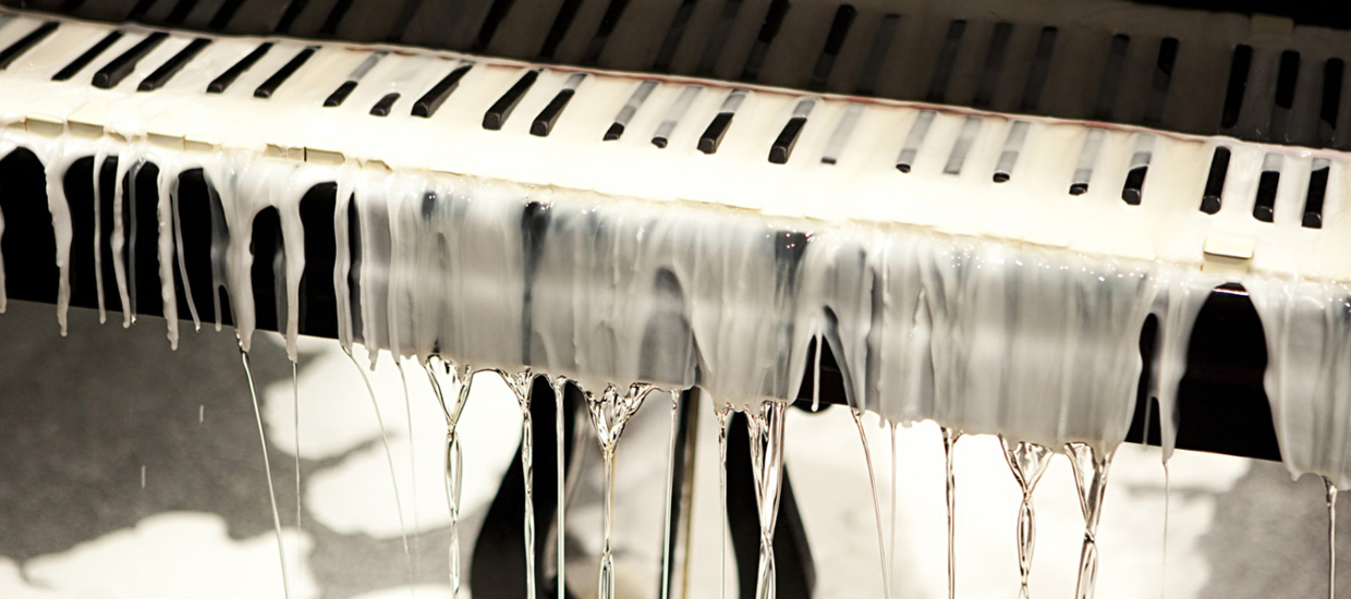 image of a piano with white melted wax all over it