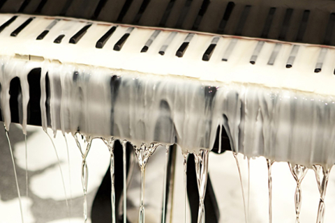 image of a piano with white melted wax all over it